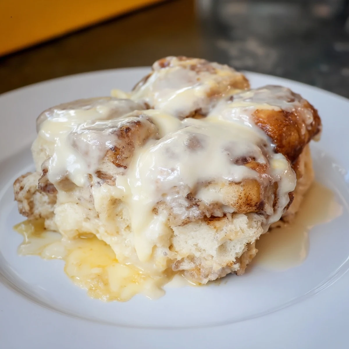 Golden-baked Cinnamon Roll Casserole with pooling vanilla icing, perfect for a cozy weekend brunch.