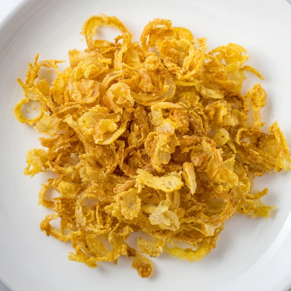 Golden, crispy fried onions, photographed close-up, tempting you to enjoy the savory crunch.