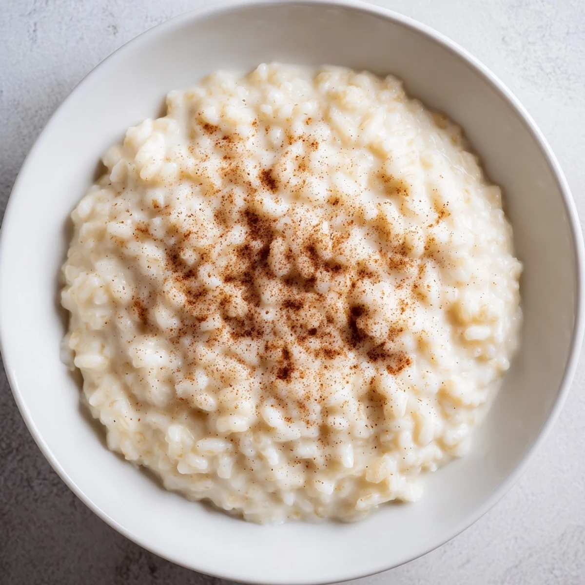 A close-up of creamy rice pudding, garnished with cinnamon, inviting you to indulge.