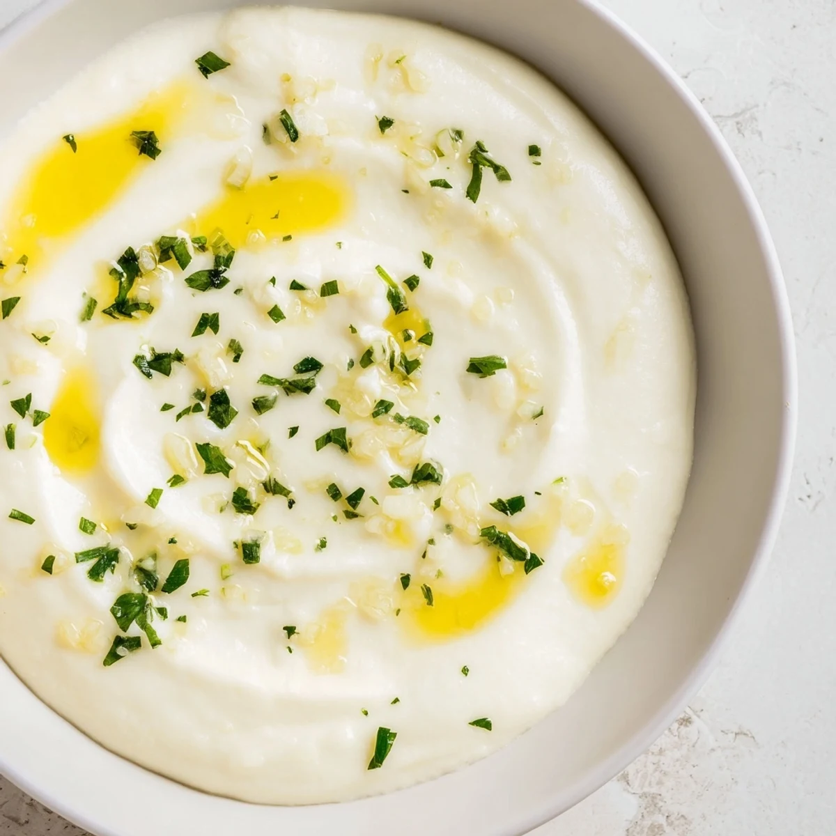 A bowl of Garlic Aioli Dip, swirled and ready to enjoy with a hint of lemon flavor.