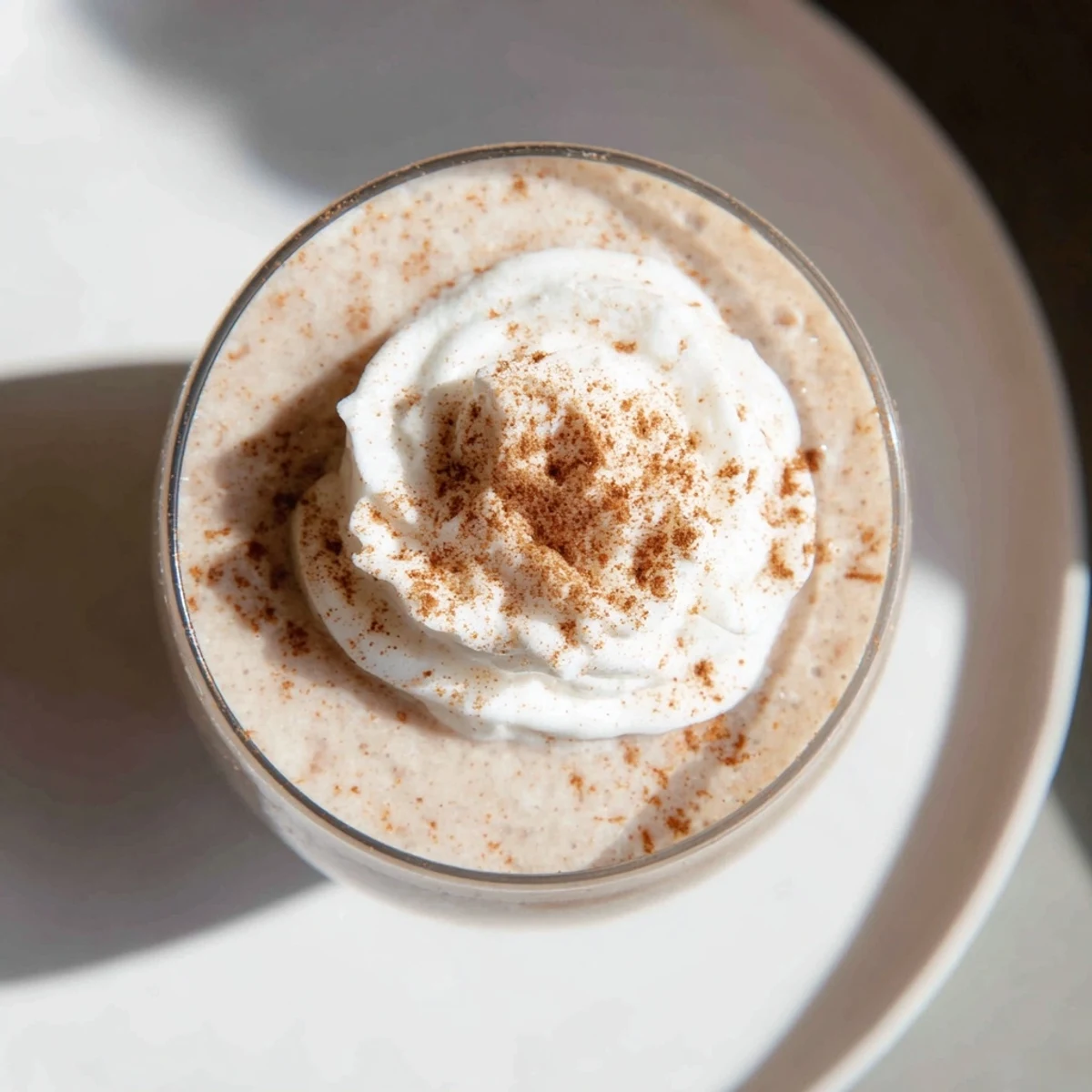 Smooth, thick Gingerbread Smoothie, topped with whipped cream and cinnamon, ready to enjoy.