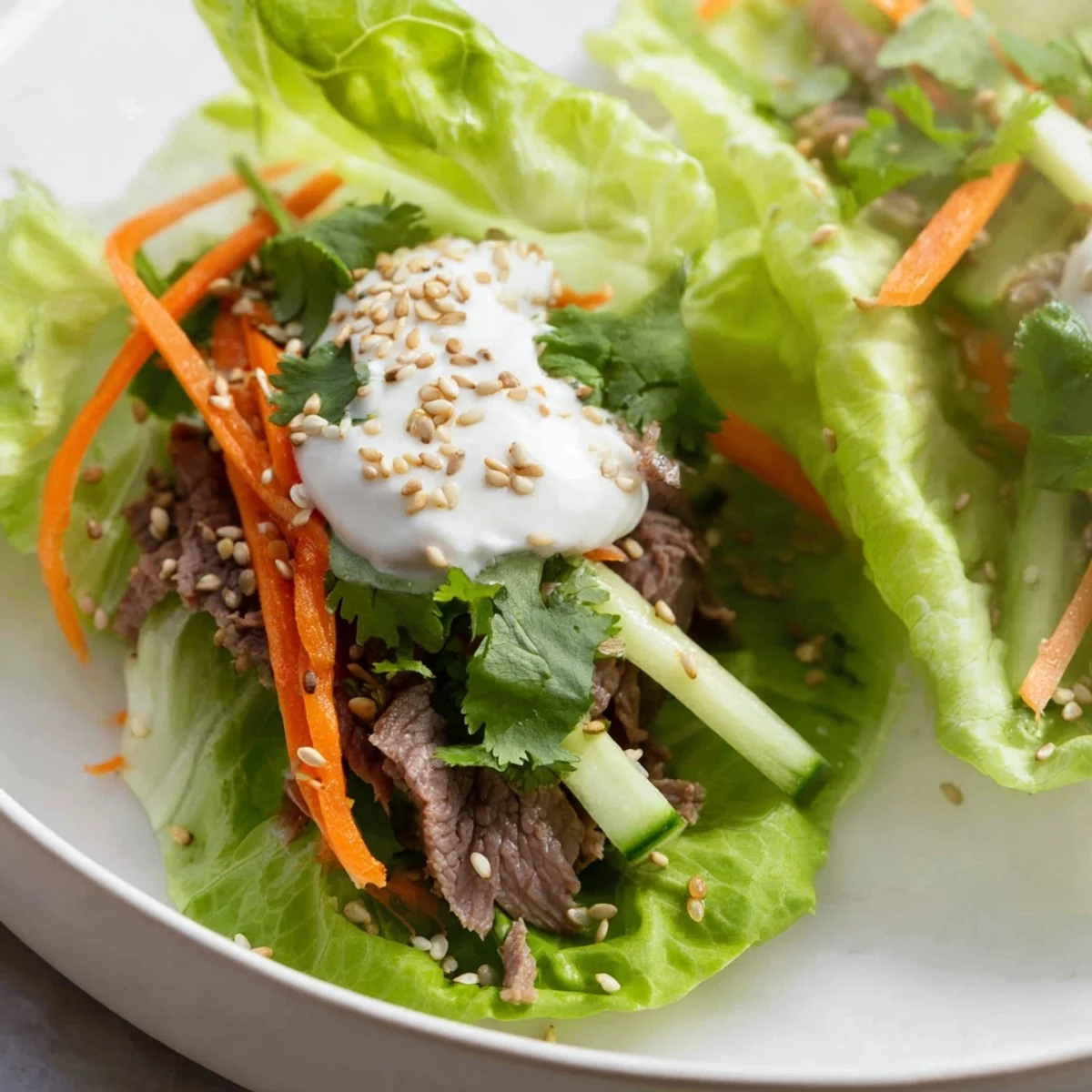 Tender marinated beef and crisp lettuce wraps are topped with creamy yogurt sauce and fresh veggies.