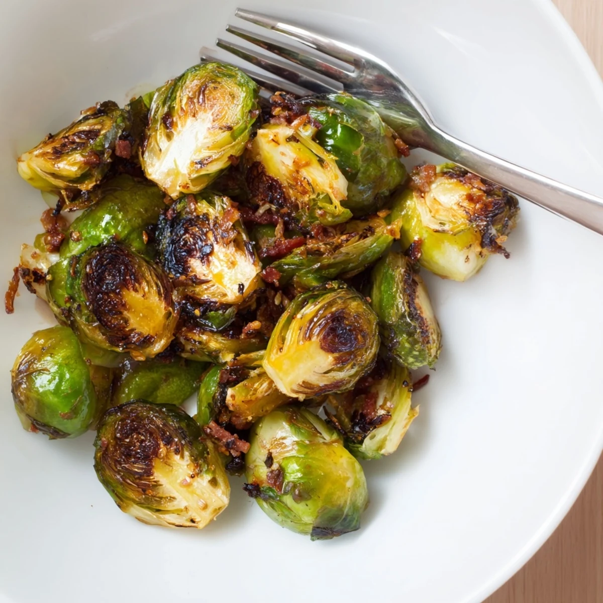 A savory plate of roasted Brussels sprouts topped with crunchy turkey bacon, drizzled with balsamic glaze and ready to serve.