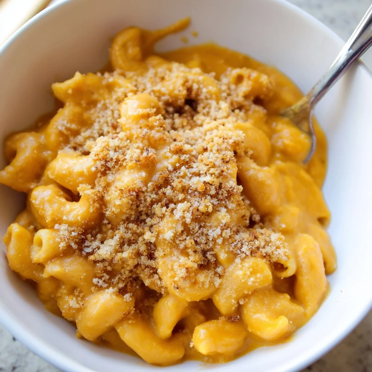Creamy Vegan Butternut Squash Mac and Cheese served hot in a rustic bowl, garnished with parsley and breadcrumbs.