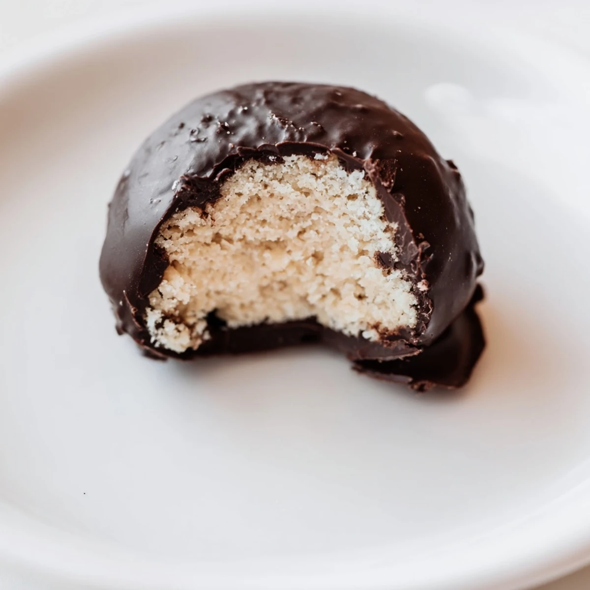 Freshly dipped Chocolate Peanut Butter Balls on a tray, showing the rich chocolate coating and soft, fudgy center in a close-up view.