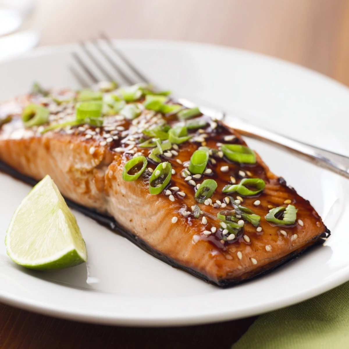 Golden-brown salmon fillets fresh from the oven, drizzled generously with homemade teriyaki sauce and garnished with sesame seeds.  