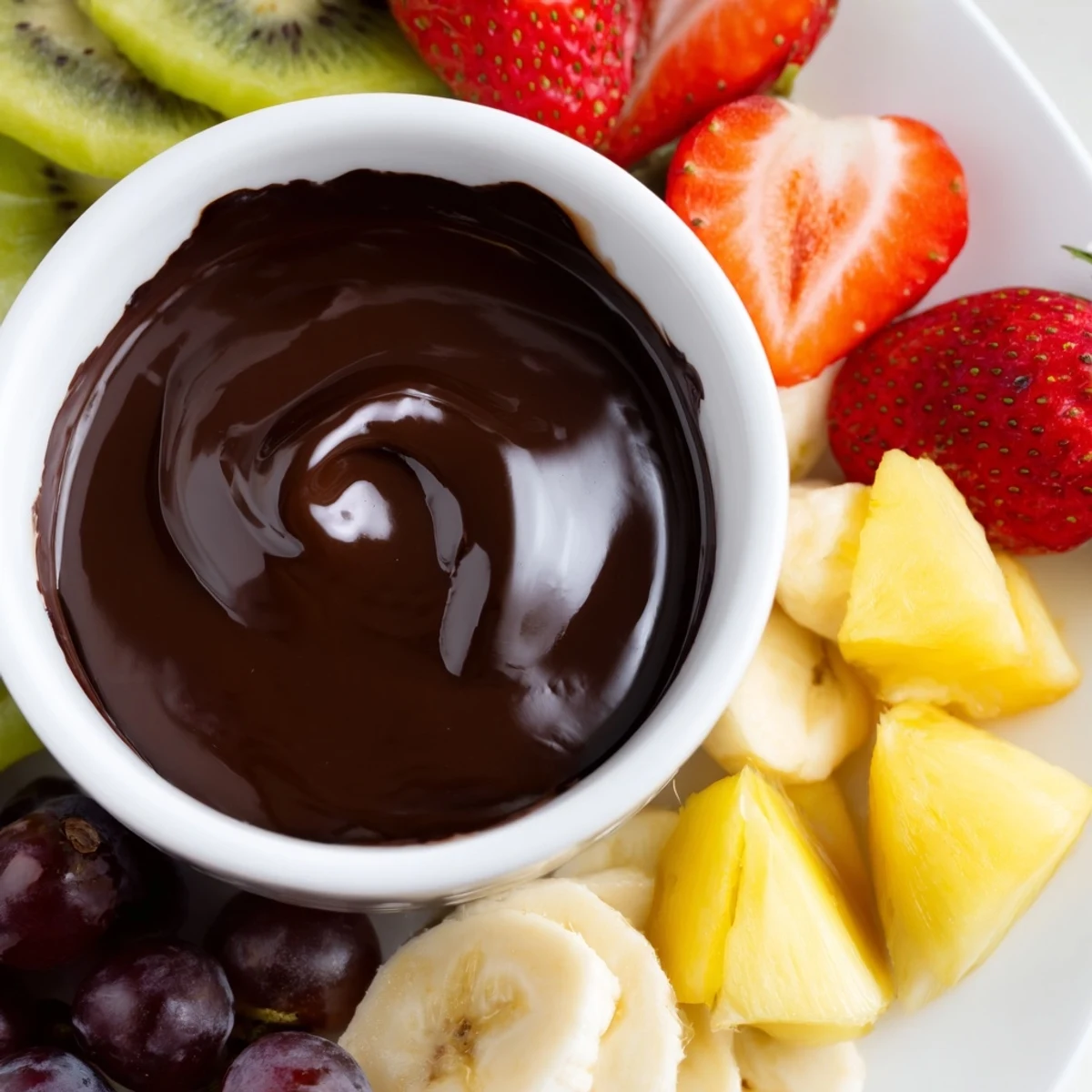 Dim candlelight glows beside a Romantic Chocolate Fondue with Fruit Platter featuring marshmallows and cake cubes.