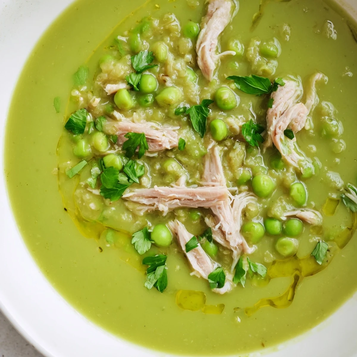 Steaming Green Split Pea Soup with Smoked Turkey is ladled from a pot, garnished with fresh parsley.