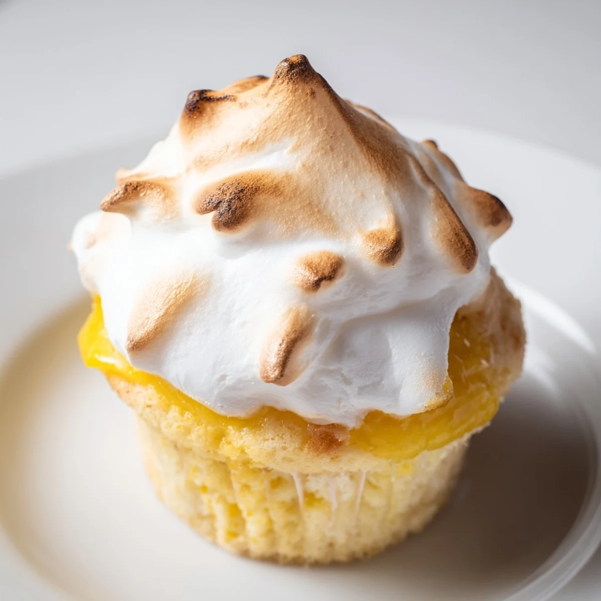 Freshly baked Lemon Meringue Cupcakes topped with tangy lemon curd and fluffy clouds of toasted meringue.