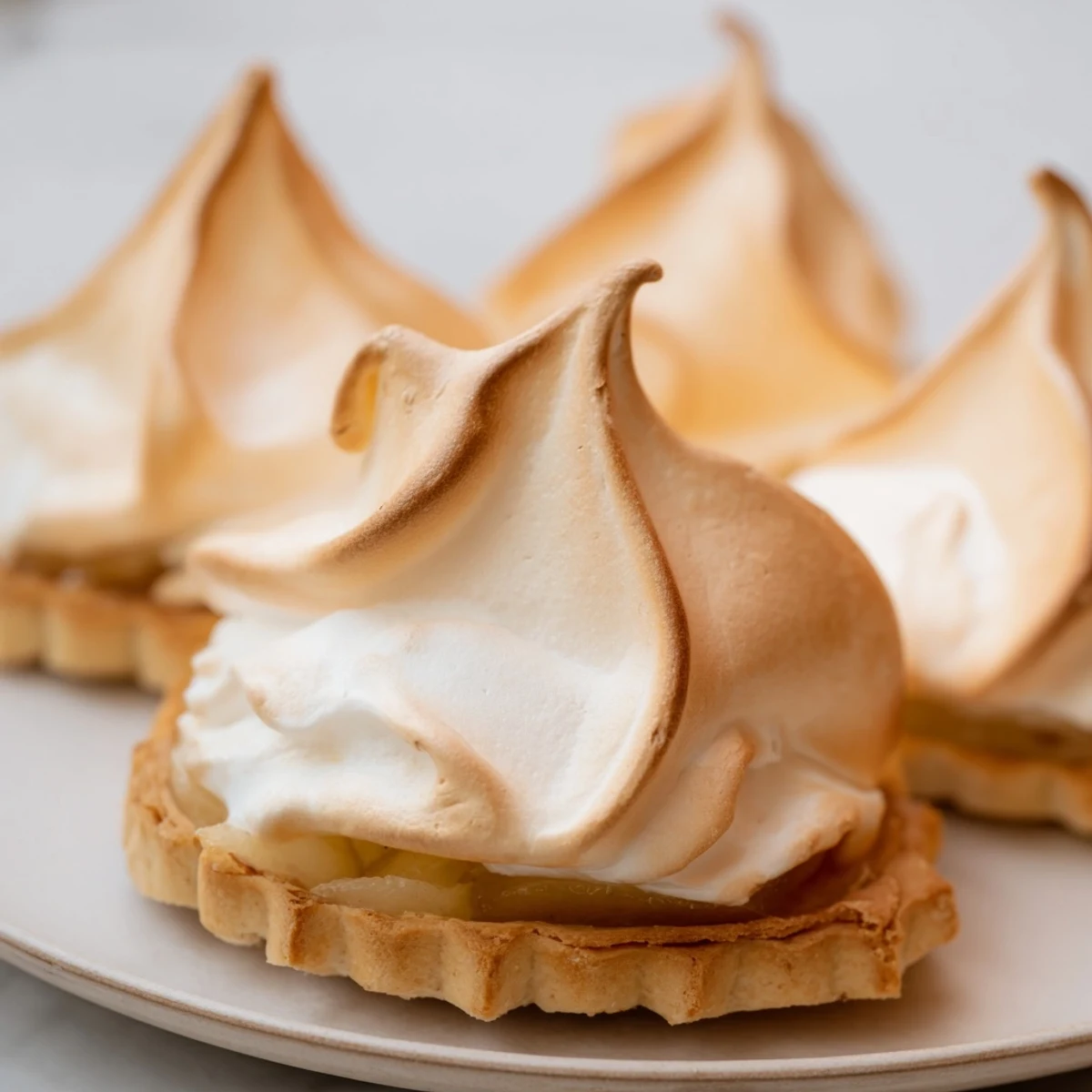 The golden Irish Apple Amber Tart emerges from the oven, featuring a flaky crust, bubbling apple filling, and a cloud of toasted meringue.  