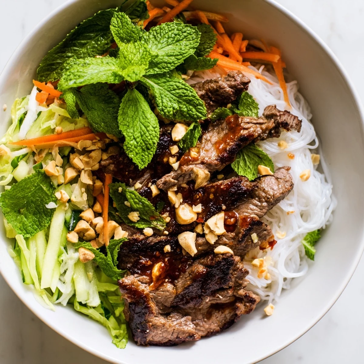 A close-up photo of Bun Bo Xao showcasing aromatic herbs and a tangy nuoc cham dressing.