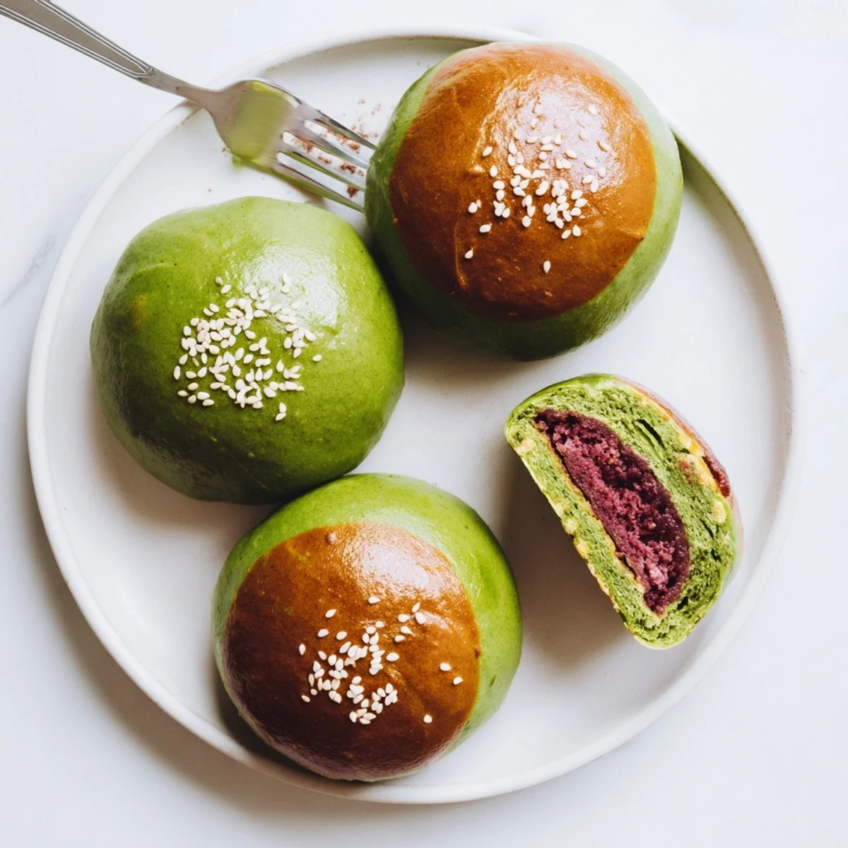 A close-up view shows the green-tinted bun torn open to reveal the sweet red bean paste filling.