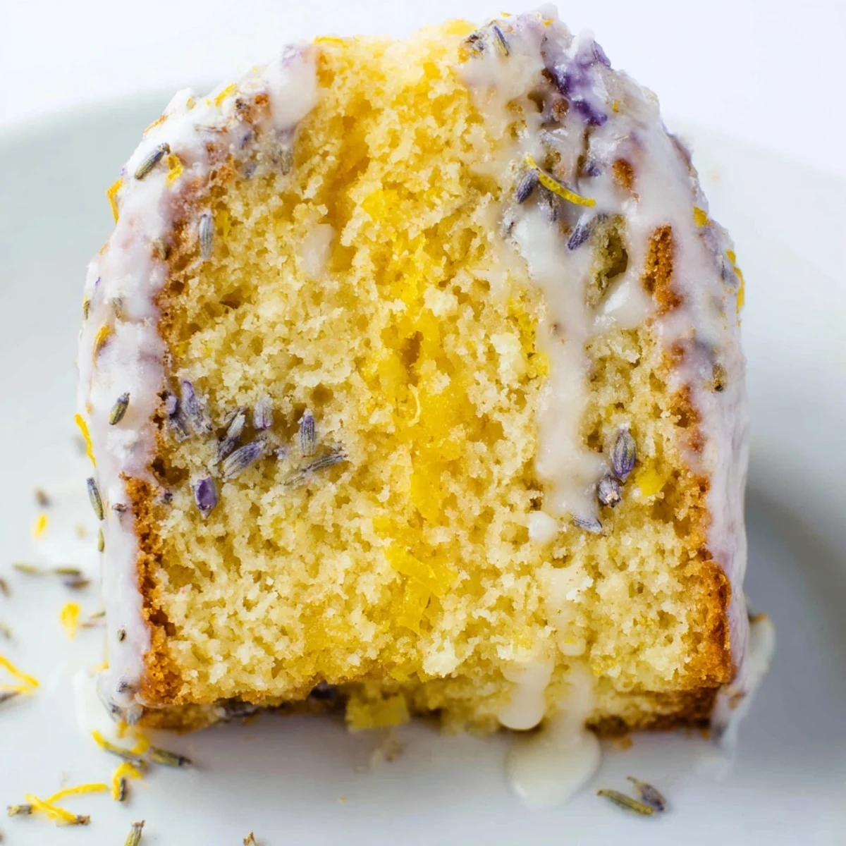 Lemon Lavender Cake with golden-brown edges, served on a wooden board with a cup of tea for afternoon dessert.