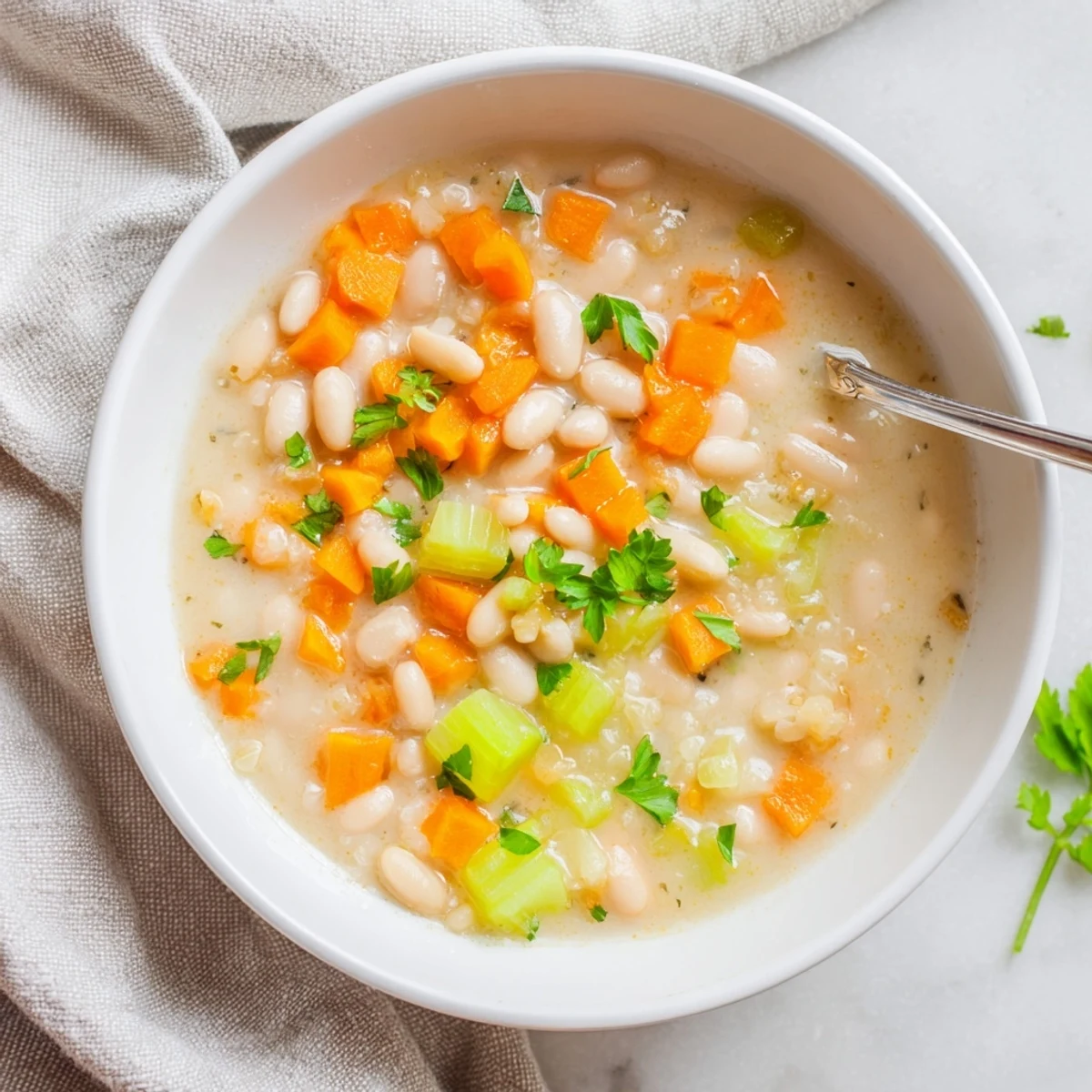 Rustic pot of Cozy Rosemary Garlic White Bean Soup on a wooden table, ready to enjoy with fresh herbs and lemon.