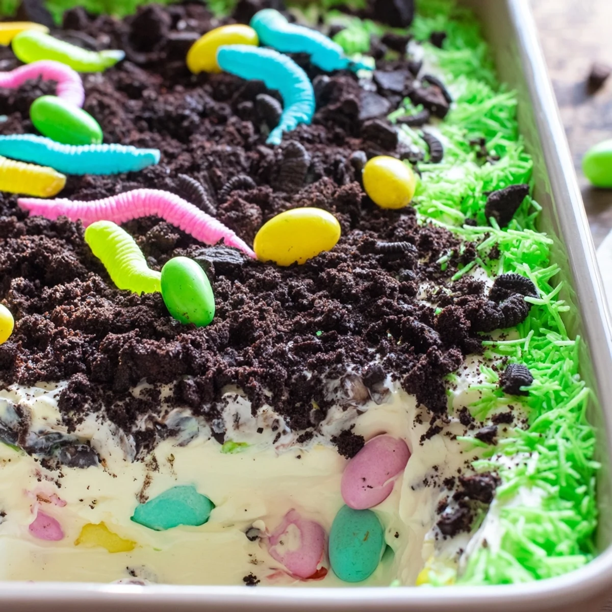 Spring-inspired Easter Dirt Cake Casserole served in a dish with candy eggs and green coconut grass.