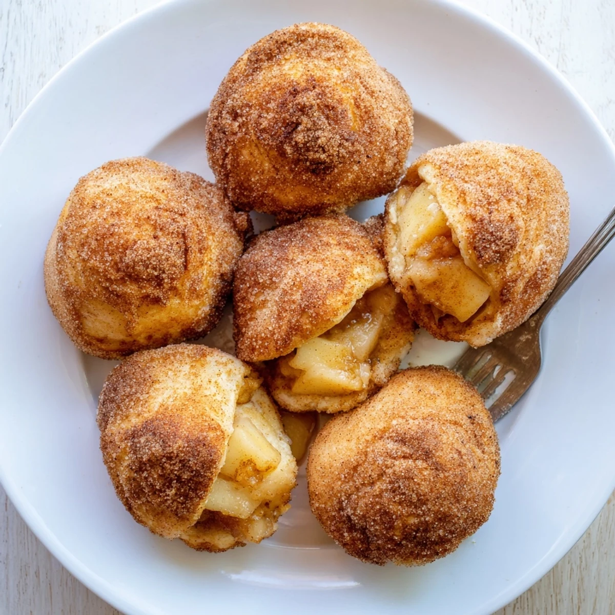 Flaky baked caramel apple pie bombs sprinkled with cinnamon sugar, ready for serving