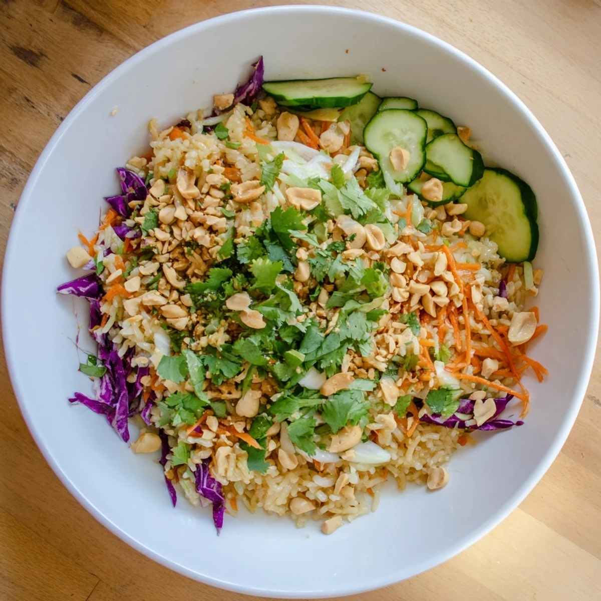 Vibrant salad featuring crispy rice, cucumber ribbons, and cilantro tossed in rich peanut sesame dressing