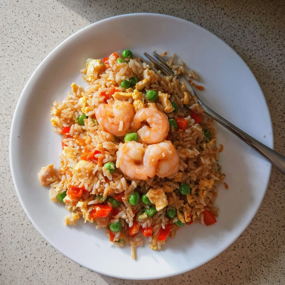 Golden garlic prawns arranged over colorful vegetable fried rice glazed with sweet chilli