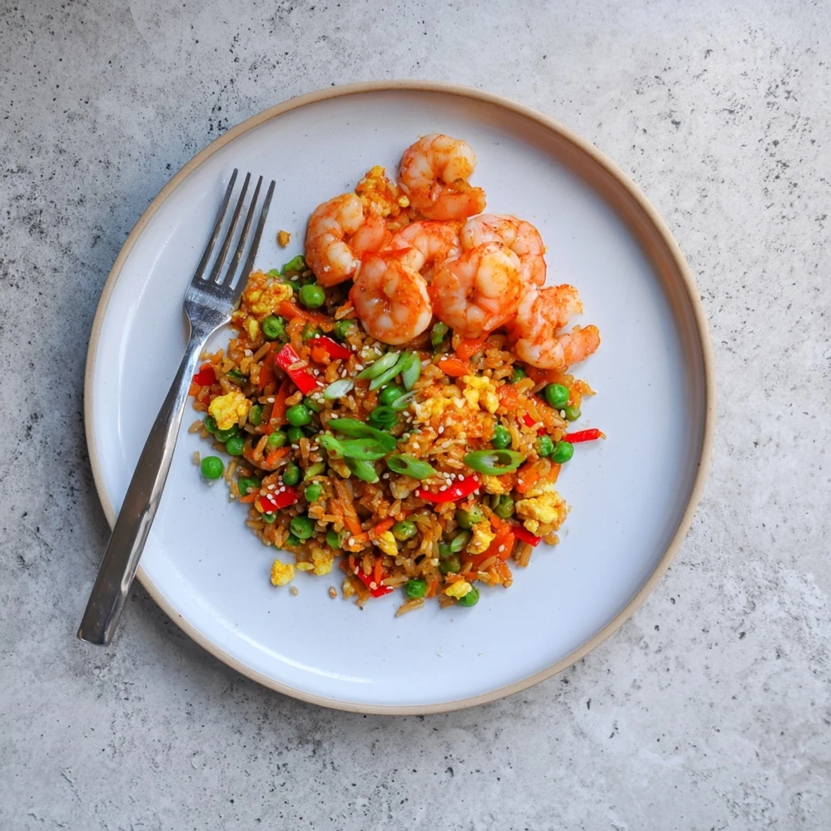 Vibrant Asian fusion dish featuring marinated prawns served over sweet chilli vegetable fried rice