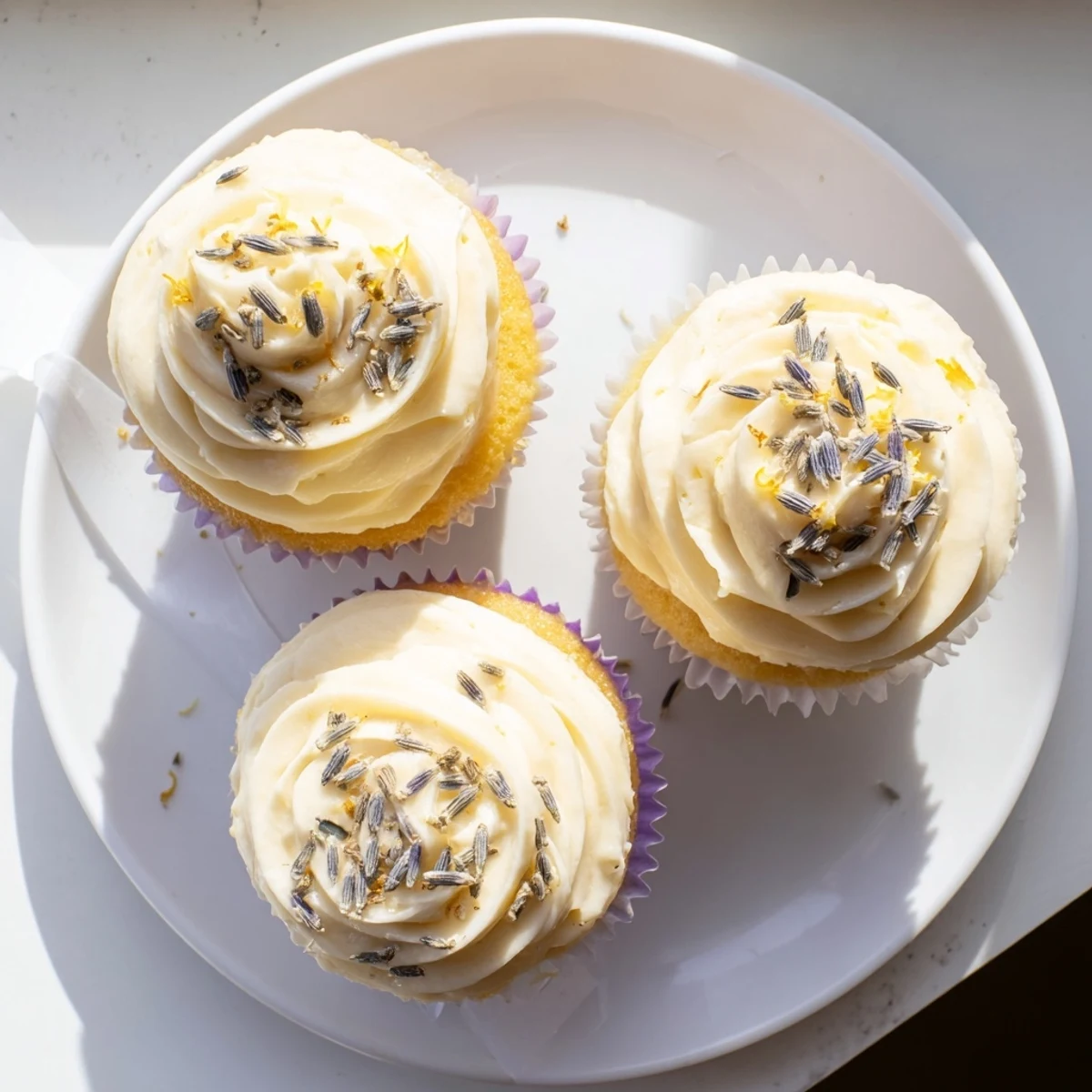 Golden lemon lavender cupcakes with swirls of lemon buttercream and dried lavender bud garnish