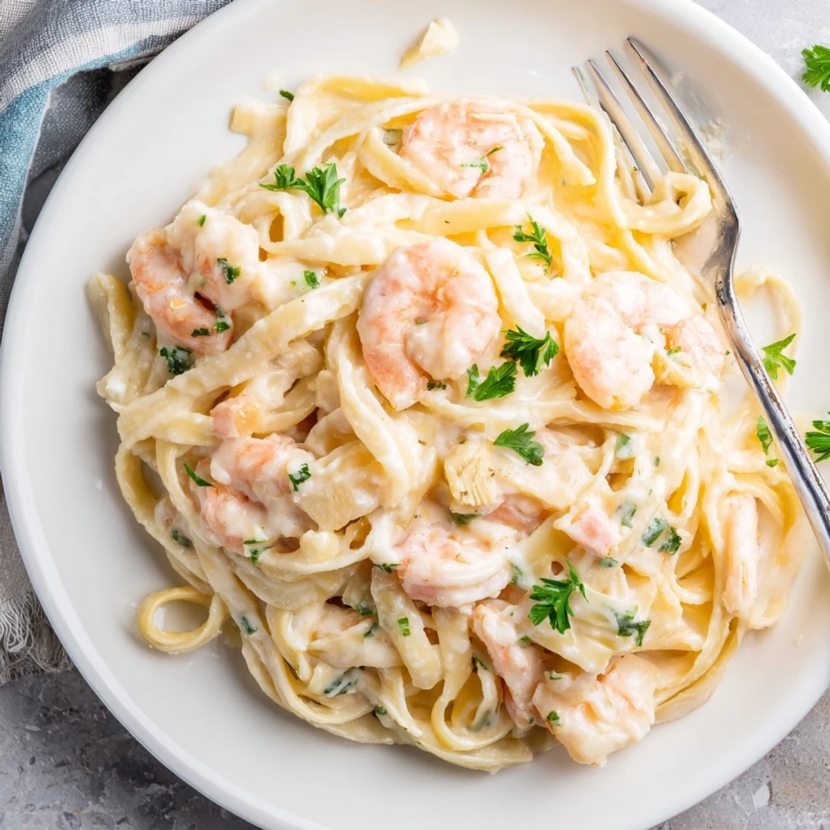 Creamy one pan shrimp fettuccine Alfredo with tender pink shrimp and rich Parmesan sauce garnished with fresh parsley