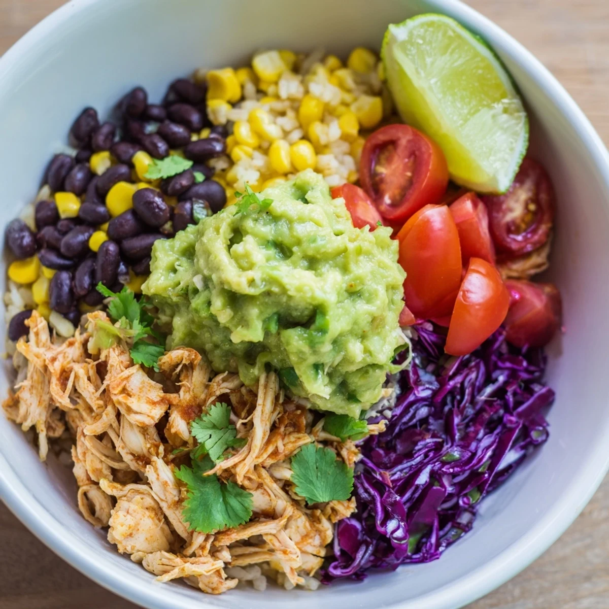 Gluten-free Tex-Mex pulled chicken guacamole bowl with black beans and colorful vegetables