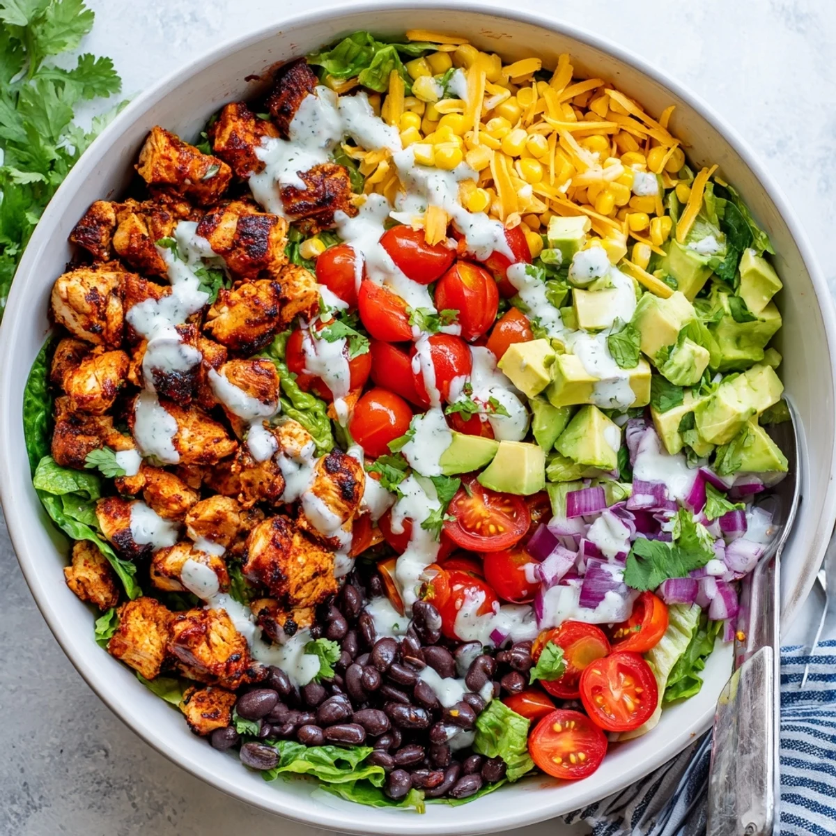 Colorful healthy BBQ chicken chopped salad bowl with grilled chicken, fresh vegetables, and creamy dressing