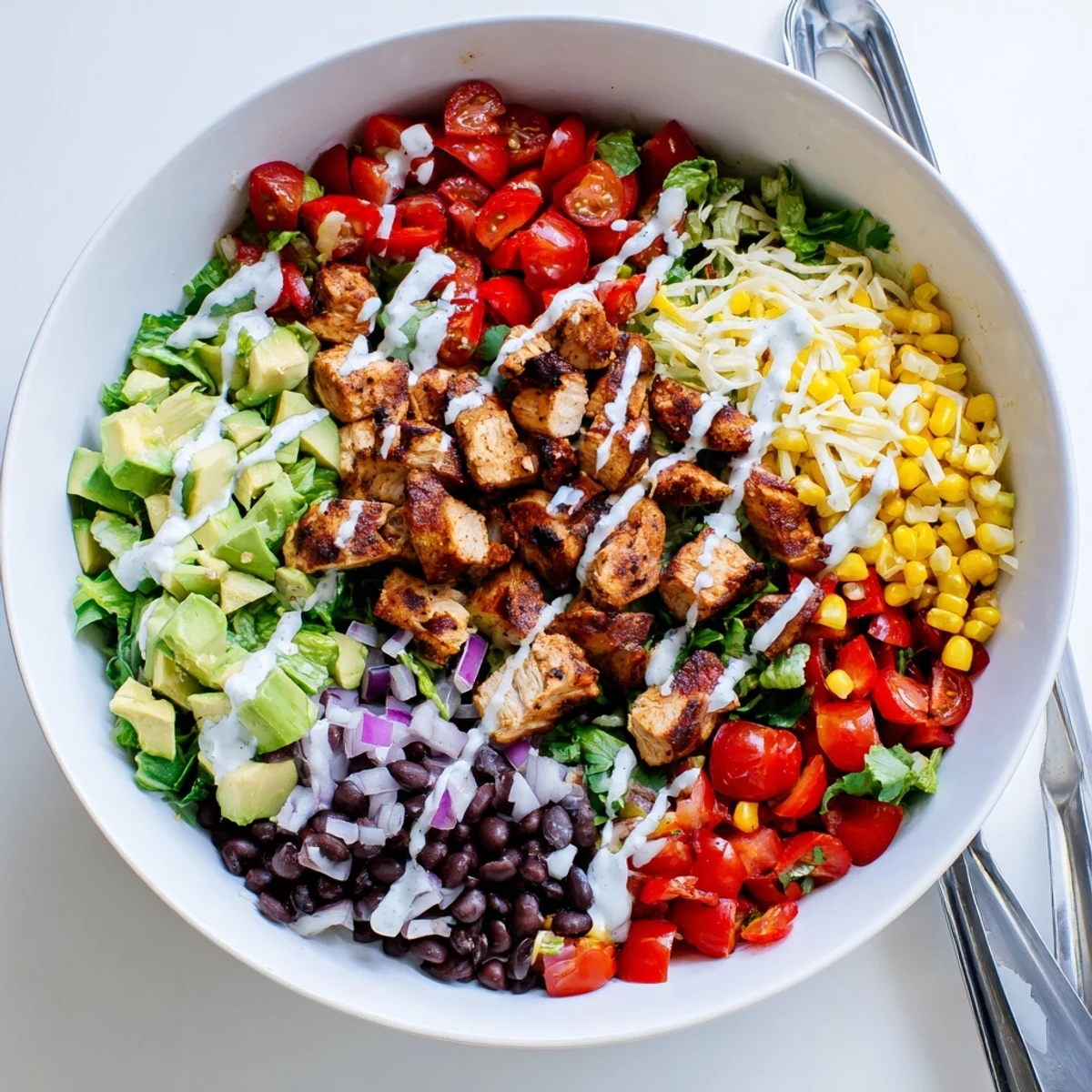 Protein-packed healthy BBQ chicken chopped salad featuring crisp lettuce, avocado, beans, and tangy glazed chicken