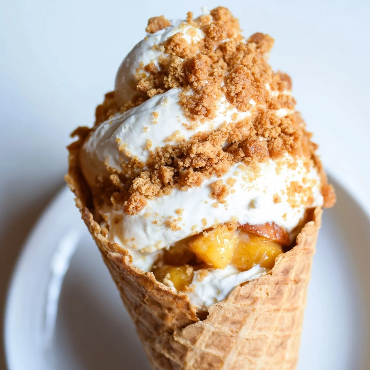 Summer dessert showing waffle cones filled with fluffy cheesecake mousse and sweet glazed peaches