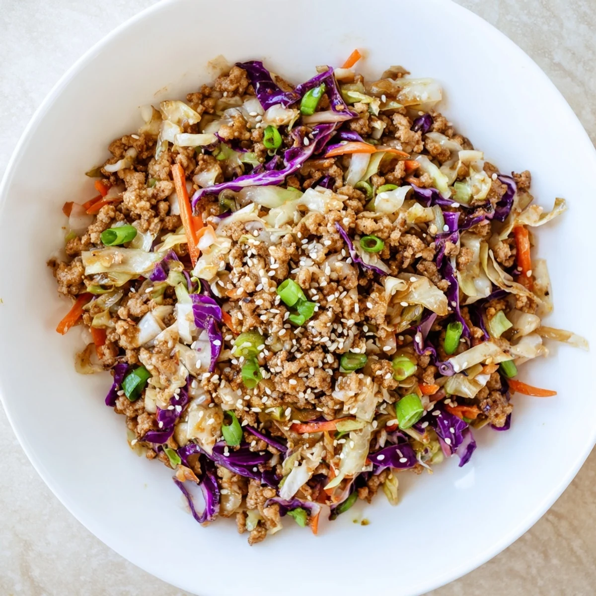 Savory egg roll in a bowl with seasoned ground pork and crisp shredded cabbage