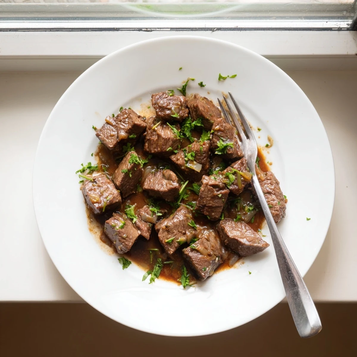 Tender slow cooker steak bites swimming in savory garlic herb butter sauce