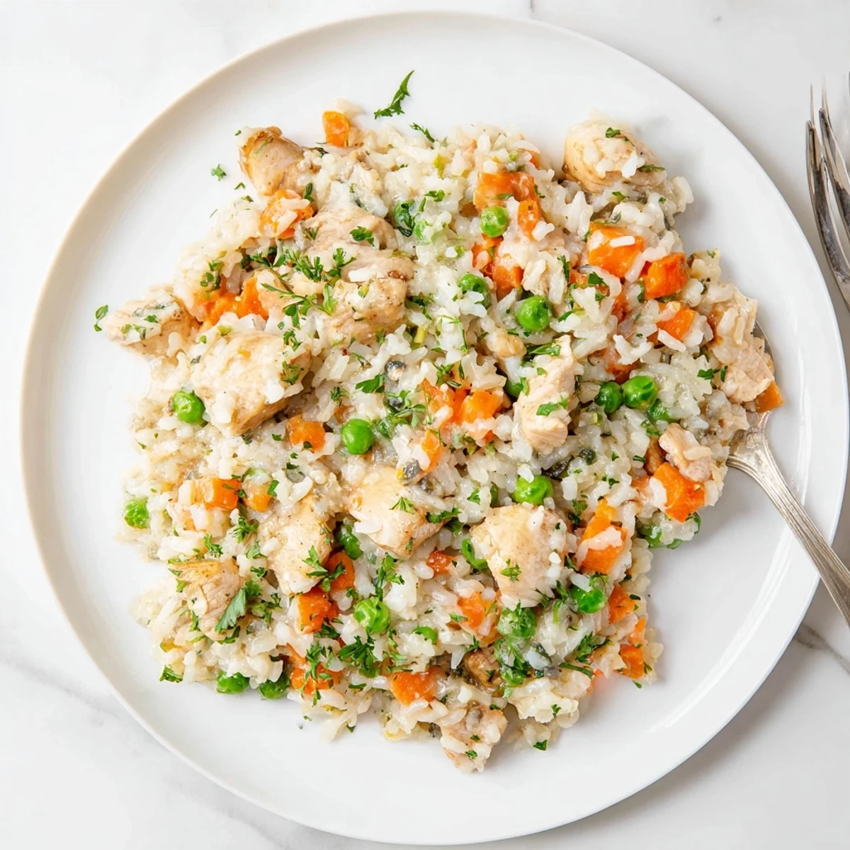 Fluffy white rice and seasoned chicken thighs loaded with colorful carrots and green peas