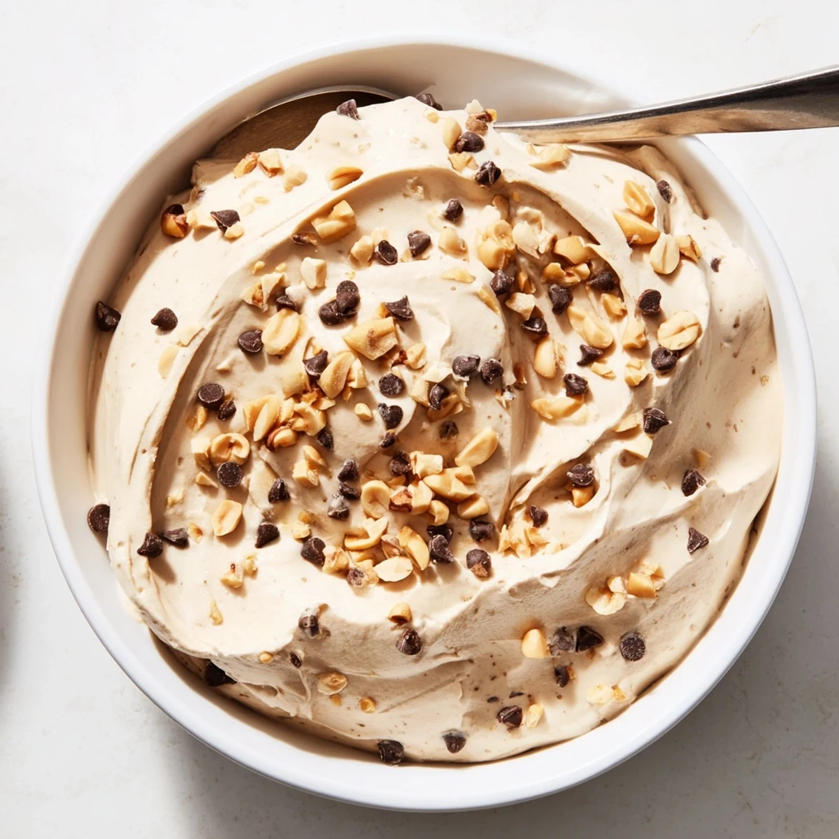 Light peanut butter mousse swirled with white fluffy Cool Whip and garnished with roasted peanuts