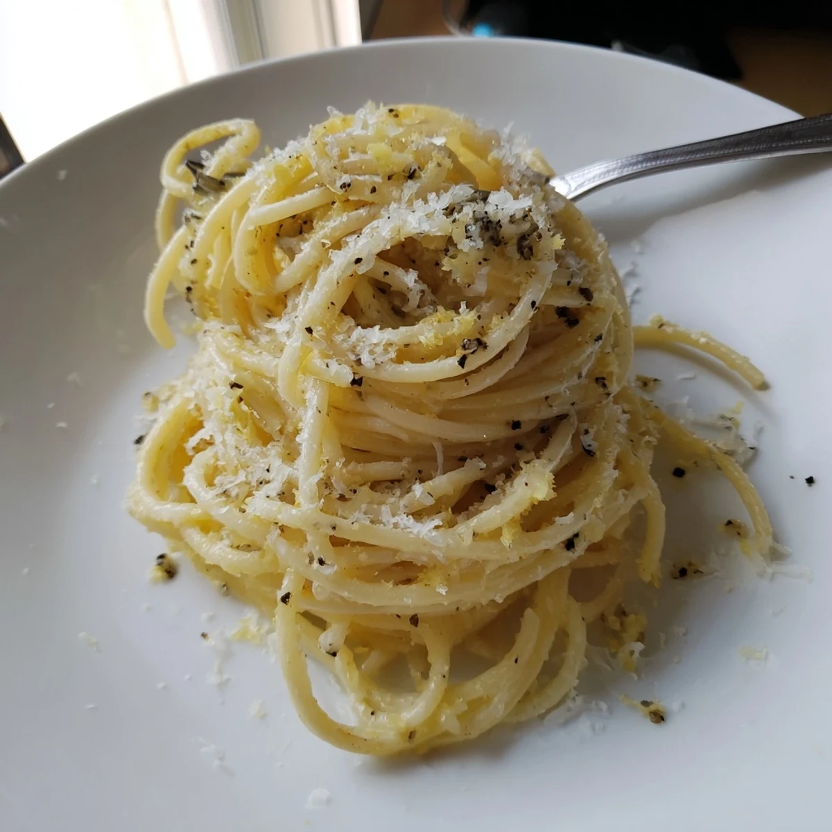 Creamy Parmesan lemon pasta tossed with garlic butter sauce in a skillet