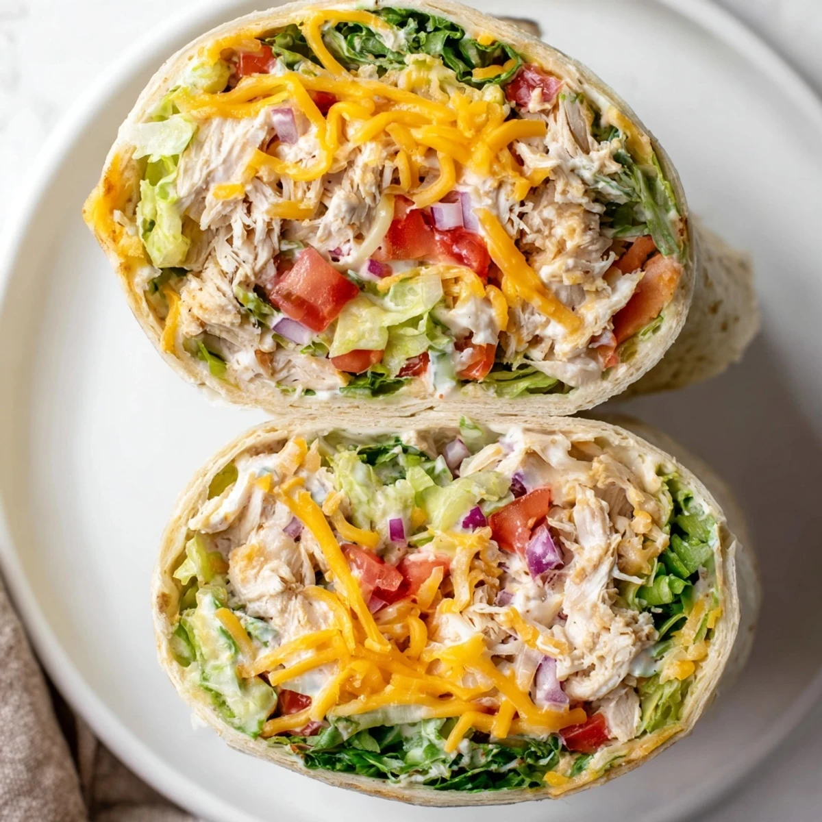 Warm Cheesy Garlic Chicken Wraps sliced open, gooey cheese and crisp lettuce