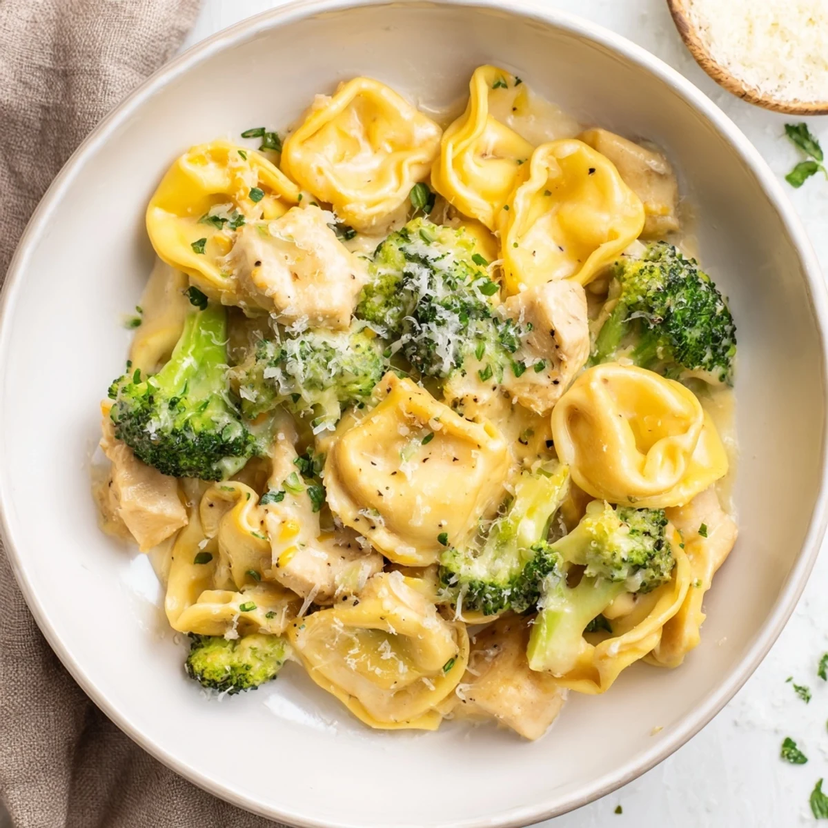 Creamy Garlic Parmesan Tortellini Chicken Broccoli Recipe steaming in skillet, cheese melting  