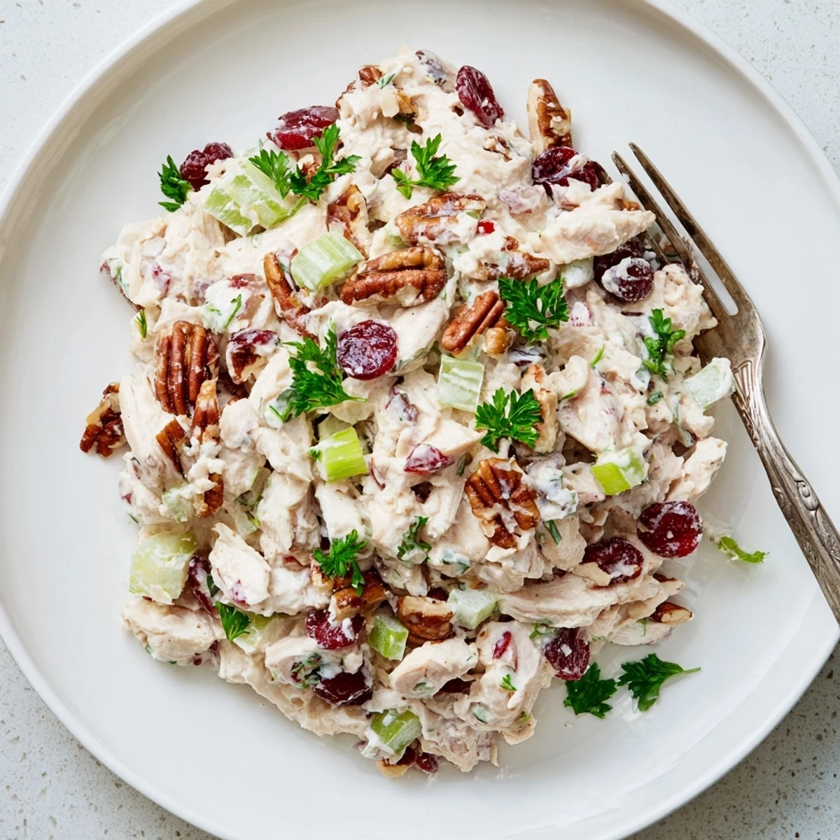 Tender chicken salad with toasted pecans and dried cranberries on a bed of fresh lettuce