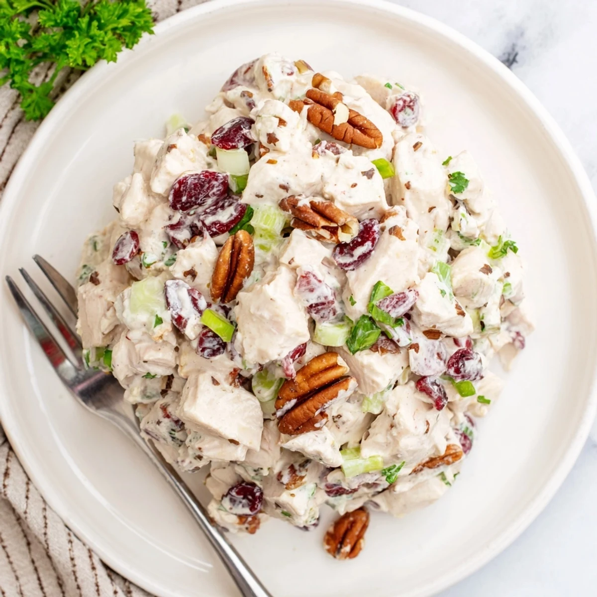 Creamy cranberry pecan chicken salad served in a white bowl with red cranberries visible