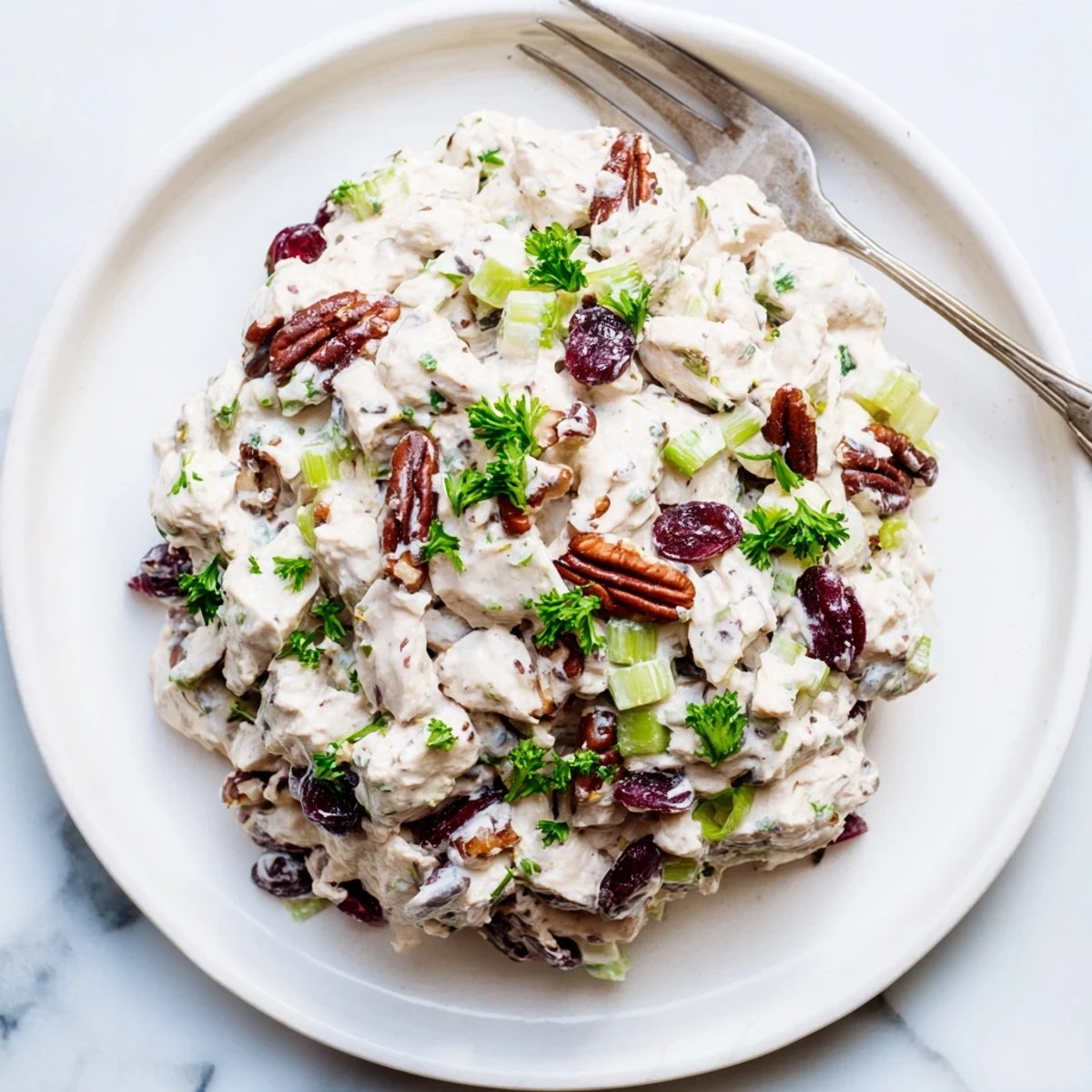 Close-up of cranberry pecan chicken salad featuring chunks of chicken, crunchy pecans, and creamy dressing
