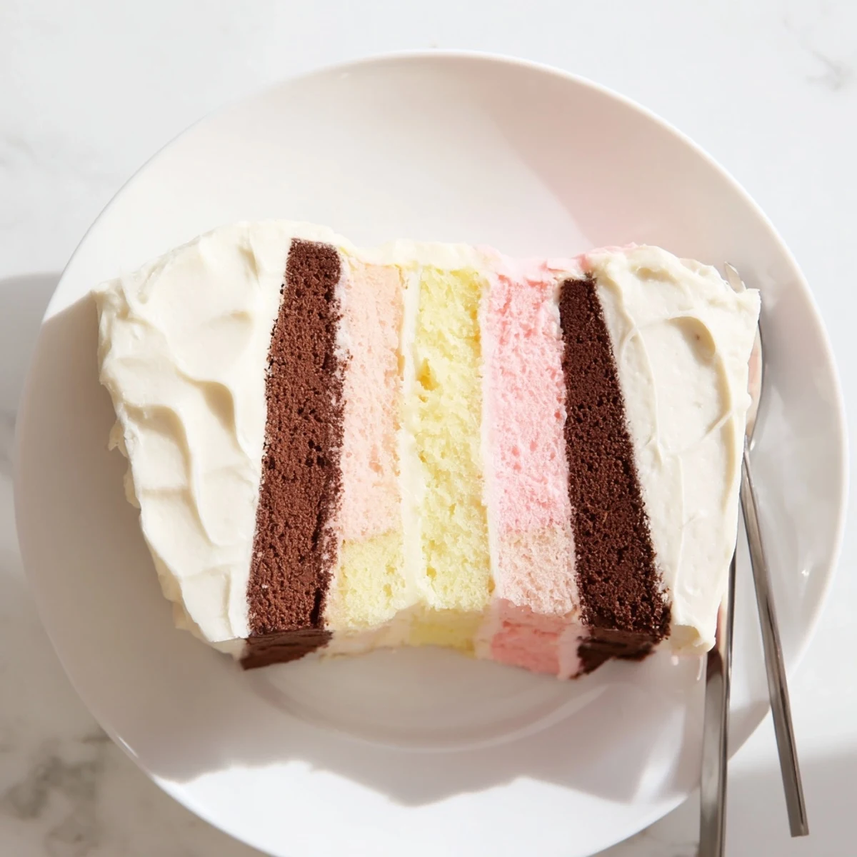 Beautiful three-layer Neapolitan cake with pink, white, and brown tiers frosted for birthday celebrations