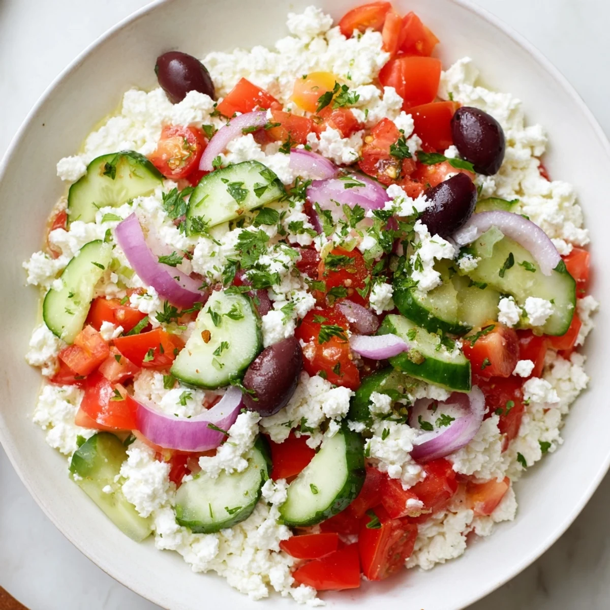 Protein-packed Greek salad cottage cheese bowl featuring fresh vegetables, tangy olives, and parsley garnish