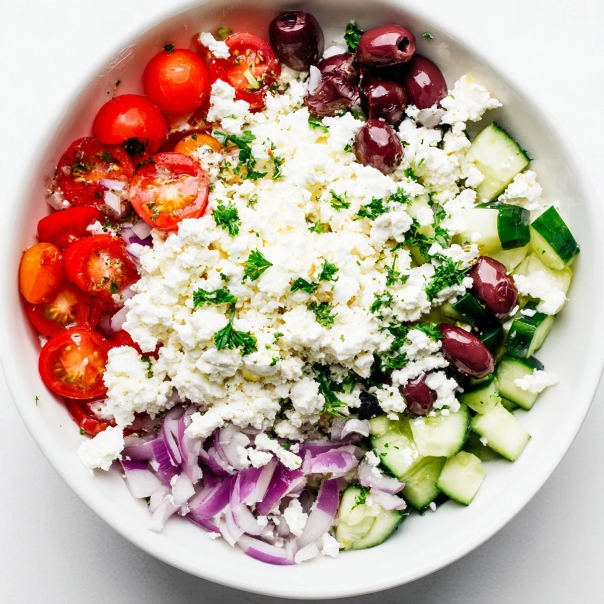 Wholesome cottage cheese bowl arranged with colorful Greek salad vegetables, olives, and feta cheese topping