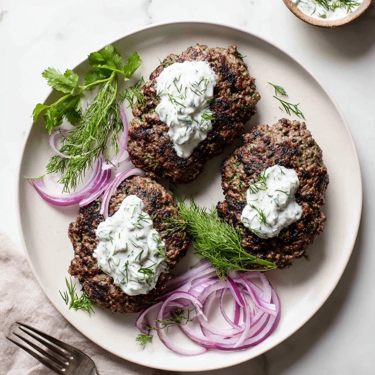 Crispy Middle Eastern smashed beef kebabs served with cool cucumber yogurt and fresh herbs