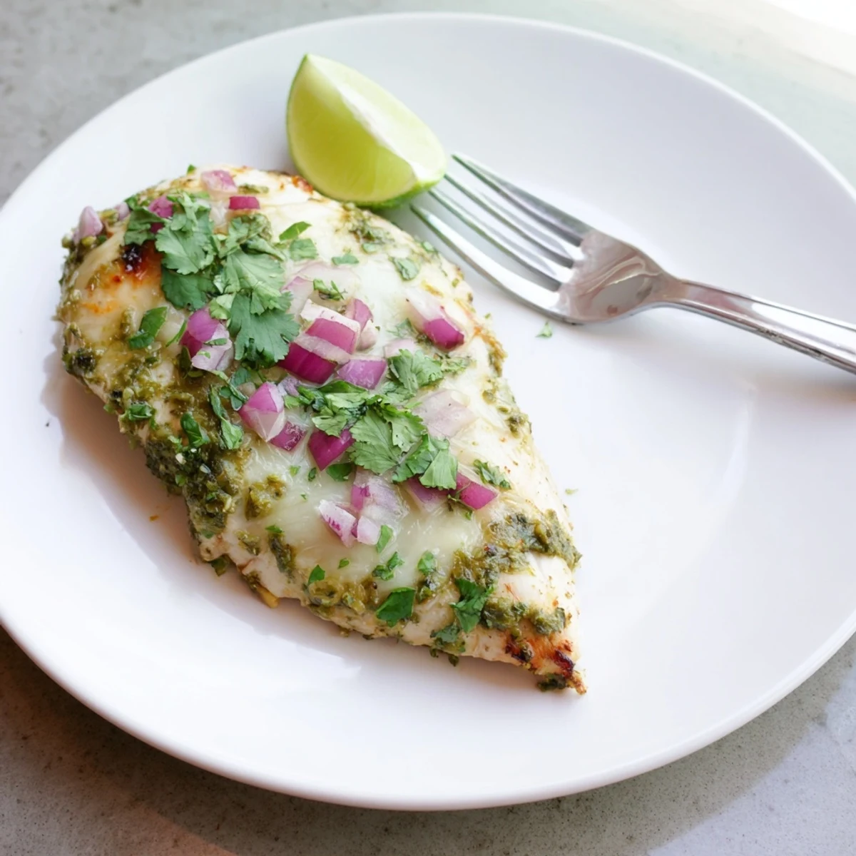 Golden grilled chicken smothered in salsa verde and bubbling Pepper Jack cheese, garnished with lime
