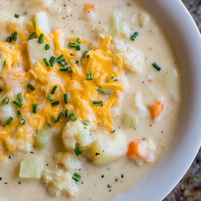 Hearty Creamy Cauliflower Chowder with Cheddar served hot in a mug alongside crunchy artisan bread for dipping.