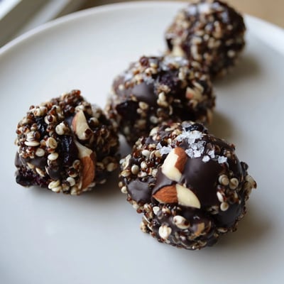 Dark chocolate Quinoa Crunch Bites nestled in paper liners with shredded coconut visible