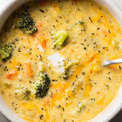 Slow cooker broccoli cheese soup garnished with golden croutons and fresh parsley